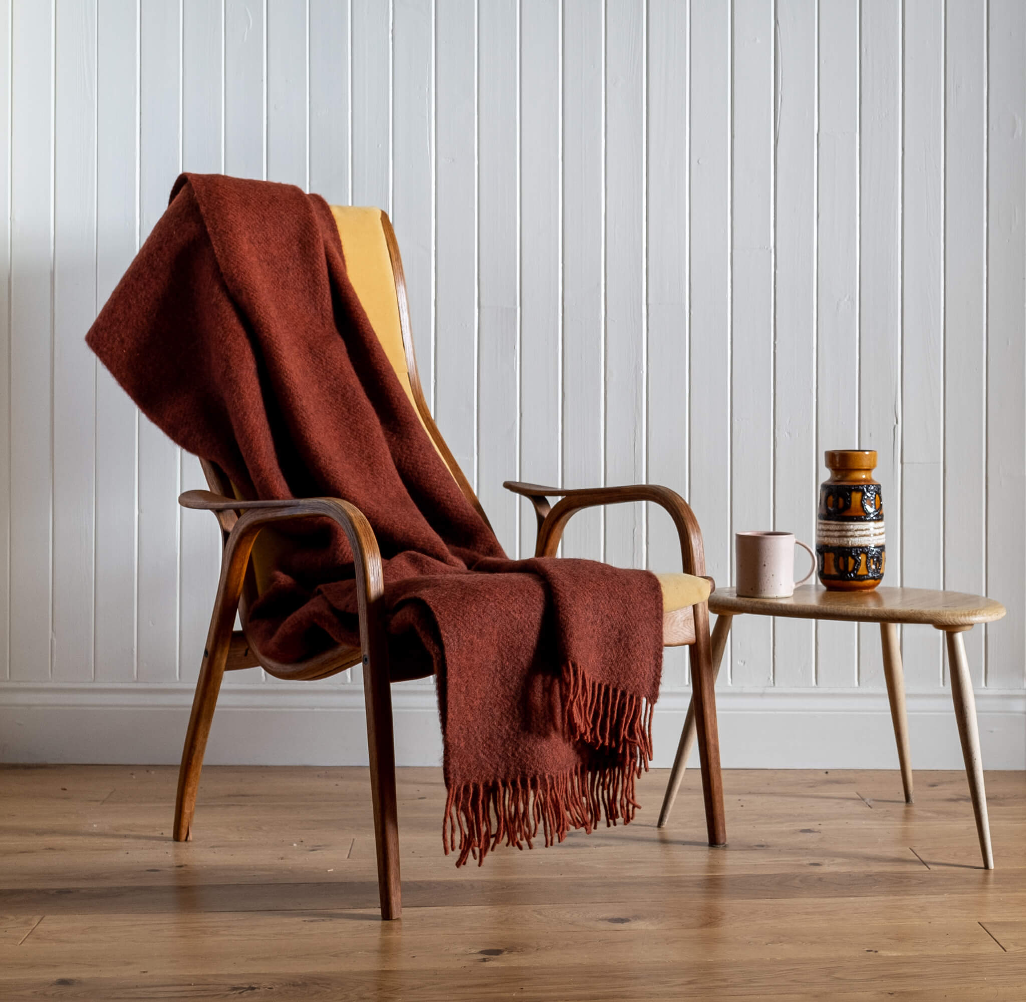 Gotland Wool Blanket – Rust, draped on a chair