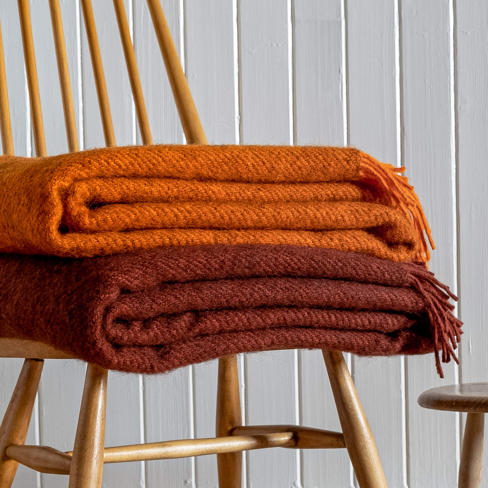 Close up of Gotland Wool Blanket – Rust & Orange folded on a chair